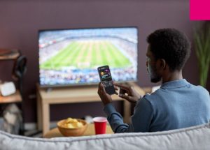 Man using his phone as a second screen while watching TV