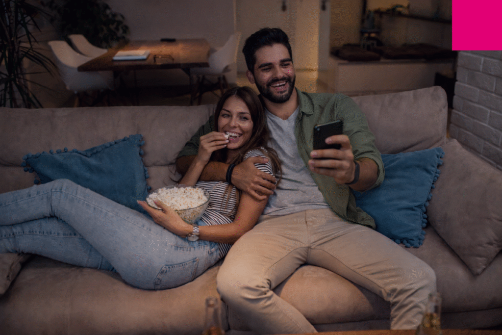 Two people watching television and taking part in an on-air interactivity activation.